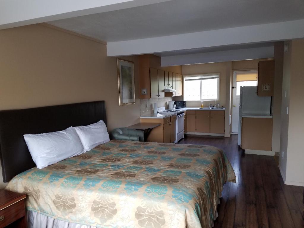 a hotel room with a bed and a kitchen at Townhouse Inn & Suites in Klamath Falls