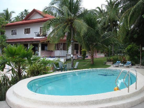 a large swimming pool in front of a house at Las Flores Beachside Hotel in Catmon