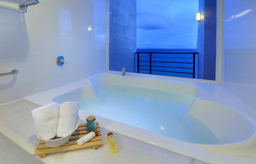 un bagno bianco con vasca e lavandino di Chateau Beach Resort Kenting a Kenting