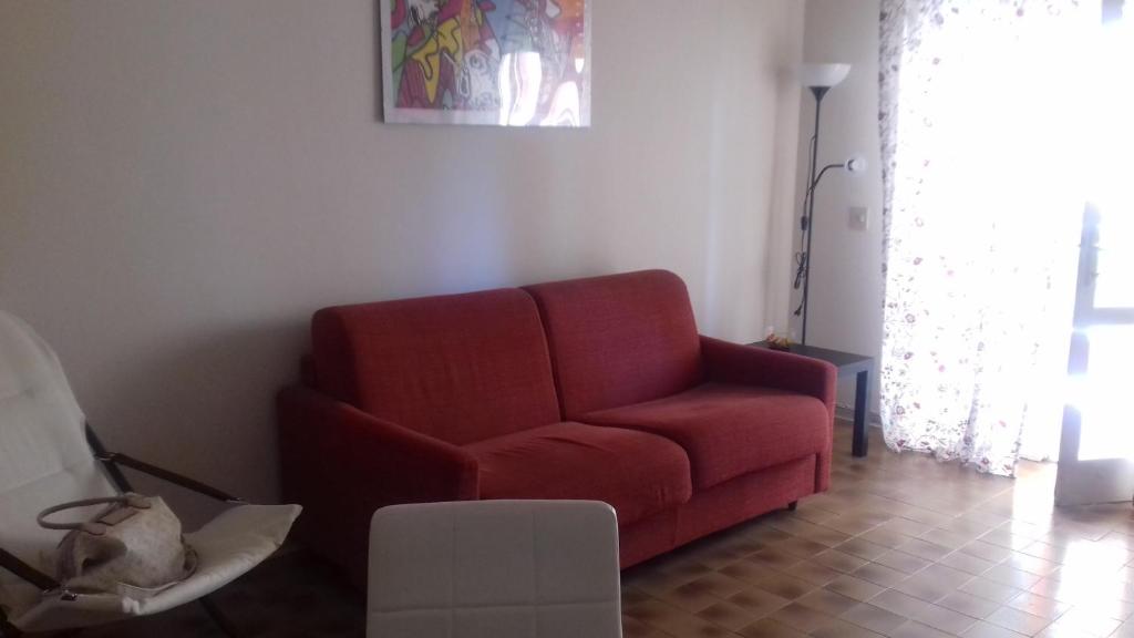リド・ディ・カマイオーレにあるCasa Ludovicaのリビングルーム(赤いソファ付)