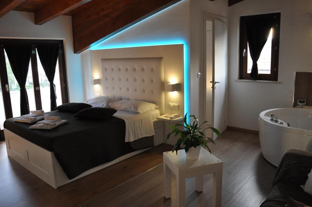 a bedroom with a large bed and a bath tub at Boutique Hotel e Spa Città Bianca in Pescara