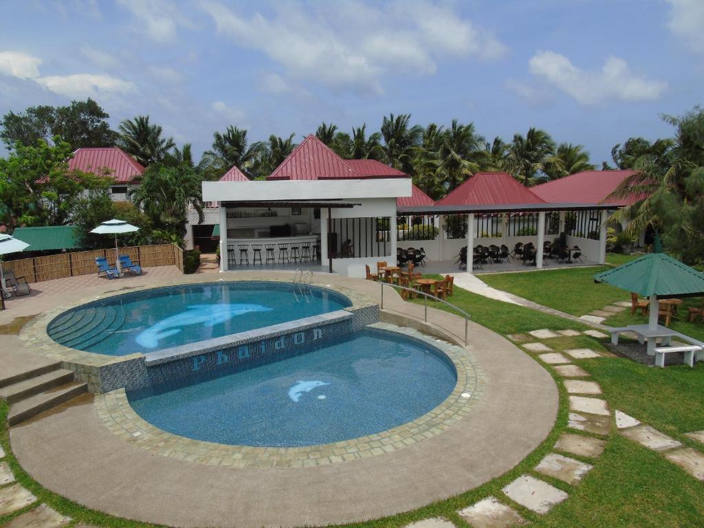 a swimming pool in front of a resort at Phaidon Beach Resort in Pandan