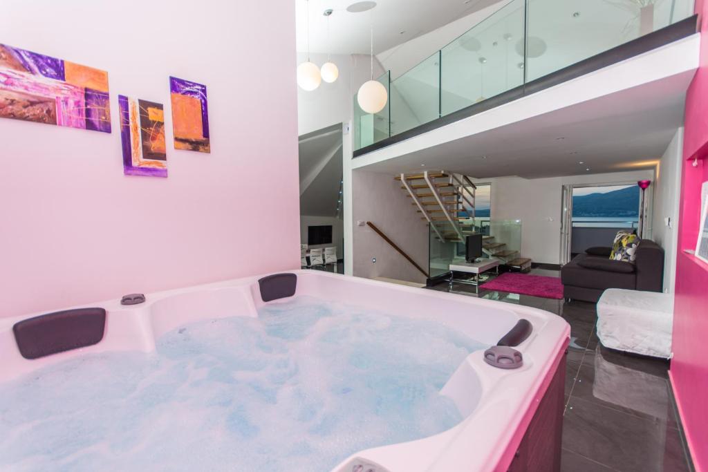eine große Badewanne in einem Zimmer mit einem Wohnzimmer in der Unterkunft Apartments Villa Pupa in Trogir