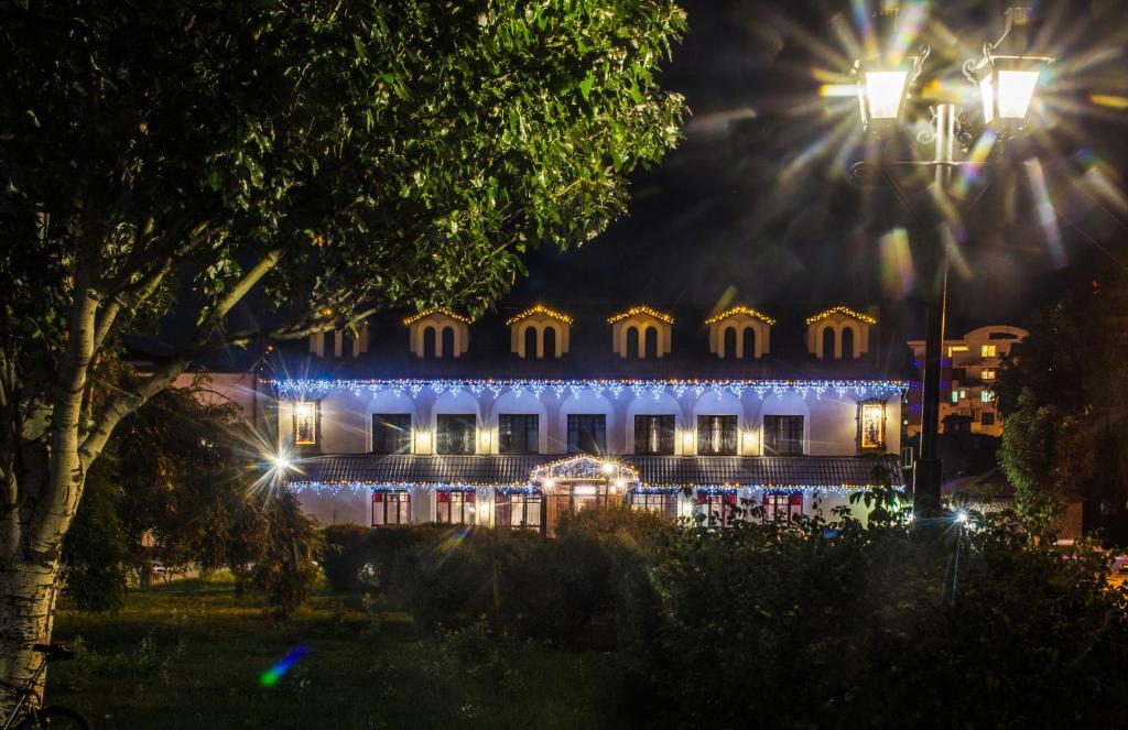un edificio illuminato di notte con luci di Lepsza Садыба a Bila Cerkva