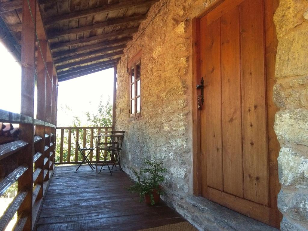 una puerta de madera en un edificio de piedra con balcón en Casa do Solpor, en La Teijeira