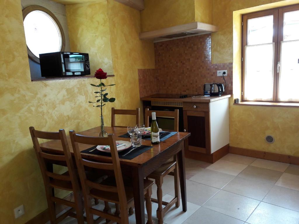 eine Küche mit einem Holztisch mit Stühlen und einem Kühlschrank in der Unterkunft le gîte de viré in Viré
