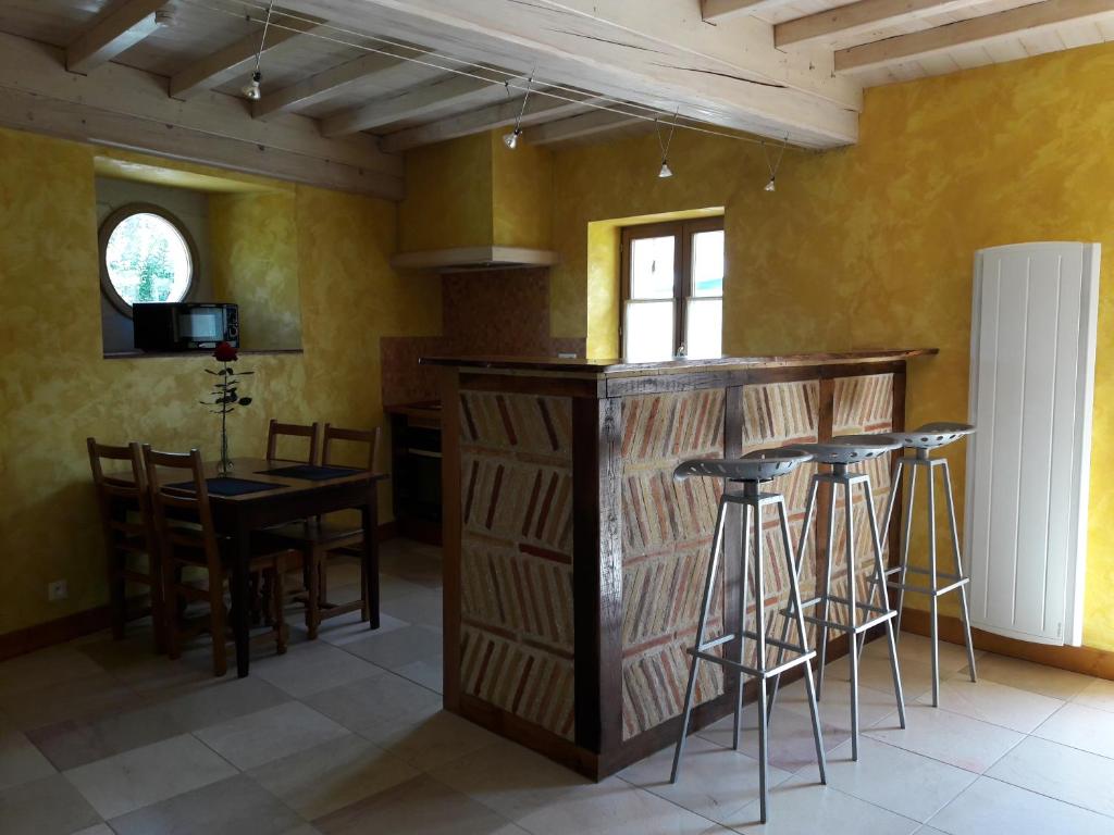 eine Küche mit einer Bar, einem Tisch und Stühlen in der Unterkunft le gîte de viré in Viré