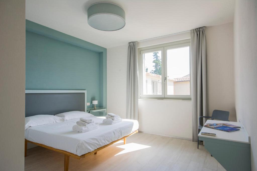 ein Schlafzimmer mit einem weißen Bett und einem Fenster in der Unterkunft Borgo Guelfo VI in Florenz