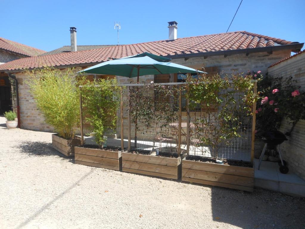 a fence with an umbrella and some plants at le gîte de viré in Viré