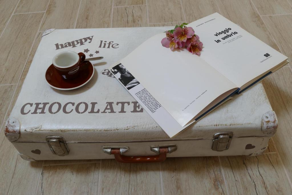 ein alter Koffer mit einem Buch und einer Tasse Kaffee in der Unterkunft Umbria in Valigia&Vecchia CasSetta in Perugia