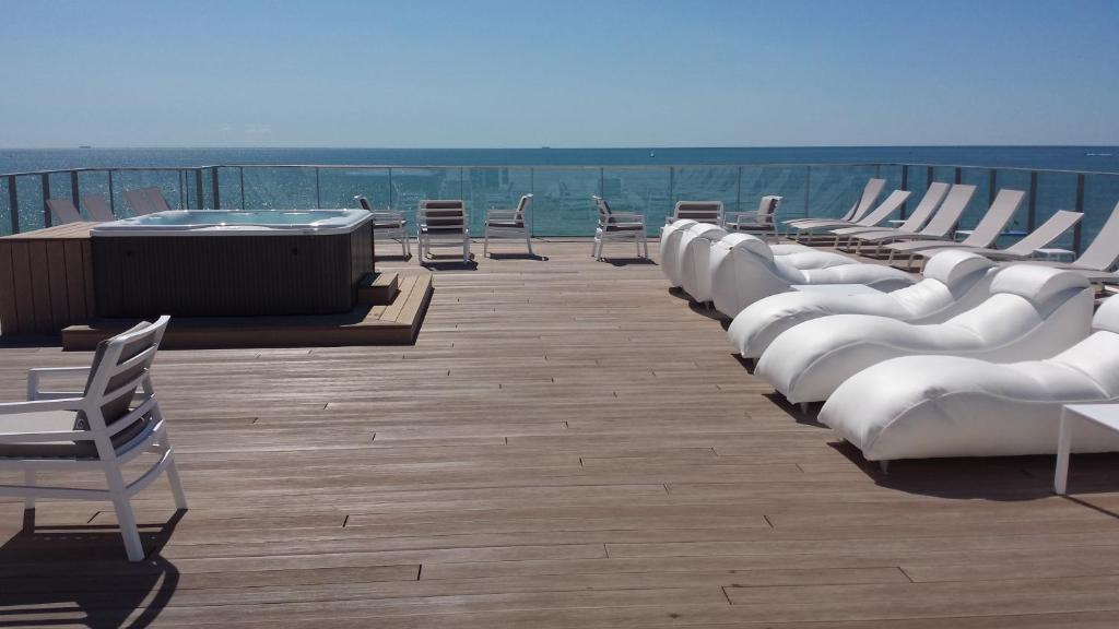 a row of white chairs sitting on a deck at Hotel Elite in Caorle