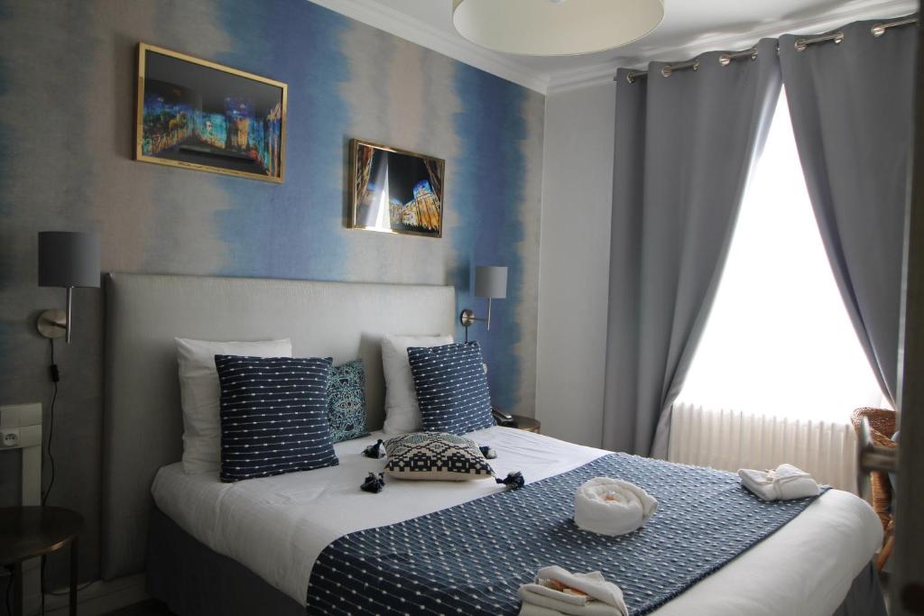 a bedroom with a bed and a painting on the wall at Régina Boutique Hotel in Avignon