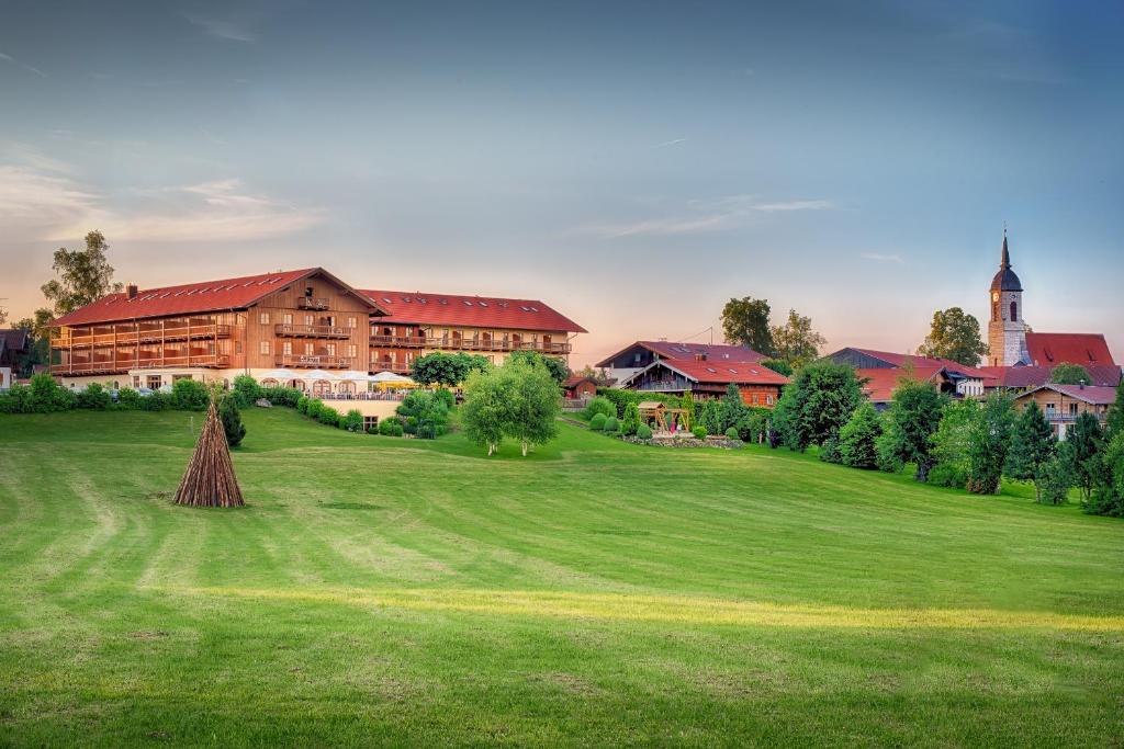 ein großes grünes Feld mit einem großen Gebäude in der Unterkunft Hotel und Landgasthof Altwirt in Großhartpenning