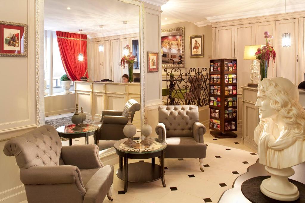 - un salon avec des chaises et un buste dans la chambre dans l'établissement Hôtel des Comédies, à Paris