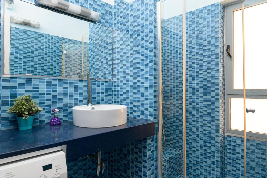 a bathroom with a sink and blue tiles at Apartment On Mapu Street in Tel Aviv