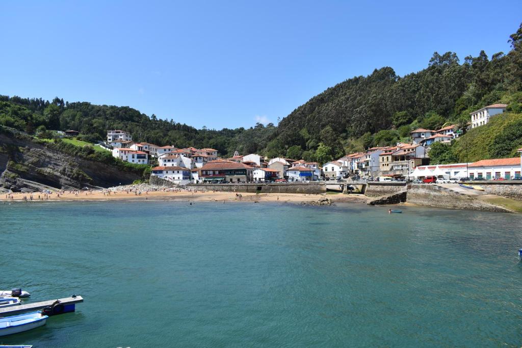 a view of a beach with houses and a town at Hotel Imperial in Tazones