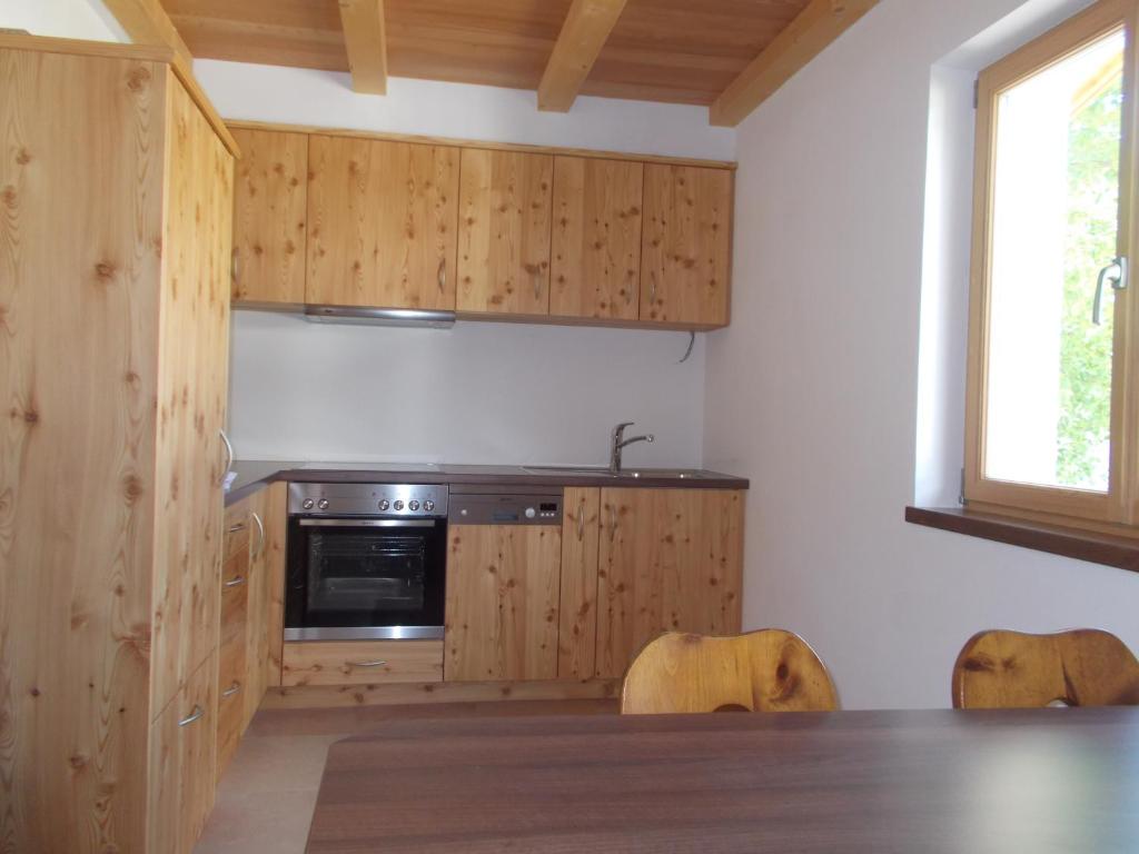 una cucina con armadi in legno e tavolo con sedie di Pichlerhof a Bressanone
