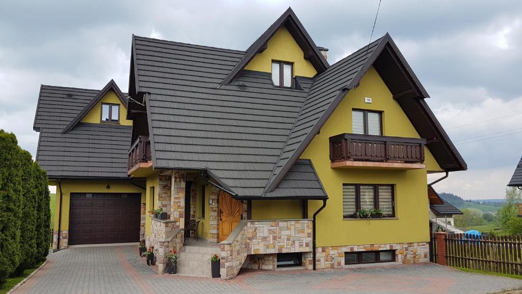 シャフラリにあるAgroturystyka Jędruś - Nocując u nas otrzymasz 20 procent zniżki na termy Gorący Potok i Szaflaryの黒屋根の黄色い家