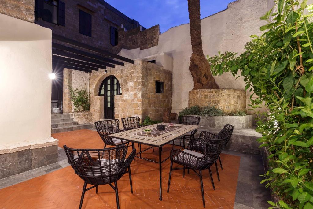 un patio al aire libre con mesa y sillas en Belvedere Medieval Villa, en Rodas