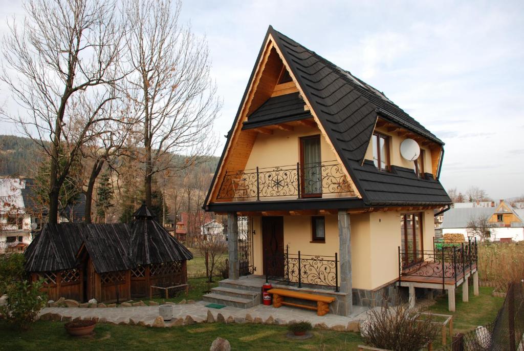 a small house with a black roof at Domek Na Wierchu i Apartament na Wierchu in Zakopane