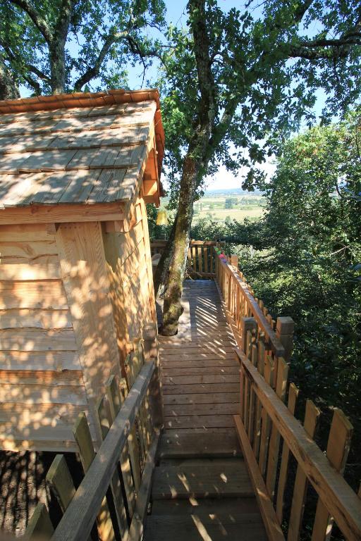 Un escalier en bois mène à un bâtiment arboré. dans l'établissement Nuits perchées à Laroque, à Saint-Antoine-de-Breuilh