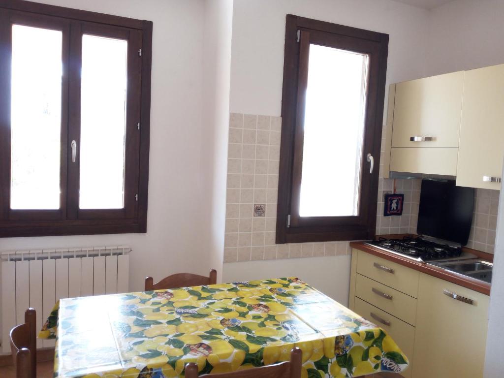 オルビアにあるApartment Olbia Holidaysのキッチン(テーブル付)、窓2つが備わります。