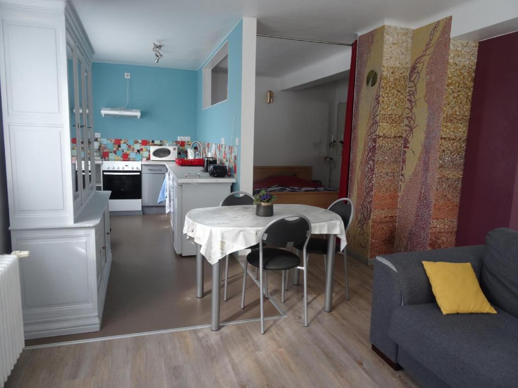 eine Küche und ein Wohnzimmer mit einem Tisch und einem Sofa in der Unterkunft Gîte du héron in La Wantzenau