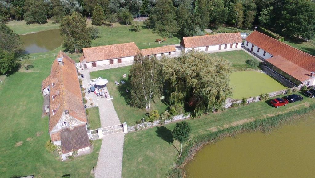 uma vista aérea de uma antiga casa com um lago em Les Portes des Froises em Saint-Quentin-en-Tourmont