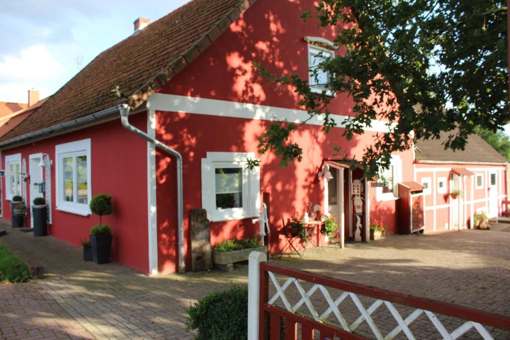 a red house with a fence in front of it at Ferienwohnung zum Nordlicht in Bassum