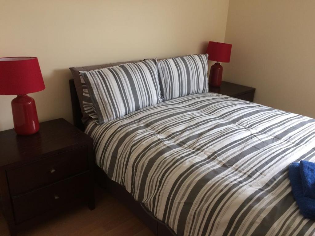 a bedroom with a bed with two lamps on night stands at MARLEY MANSIONs APARTMENTS - KING ST REF : 10/3 in Wallasey