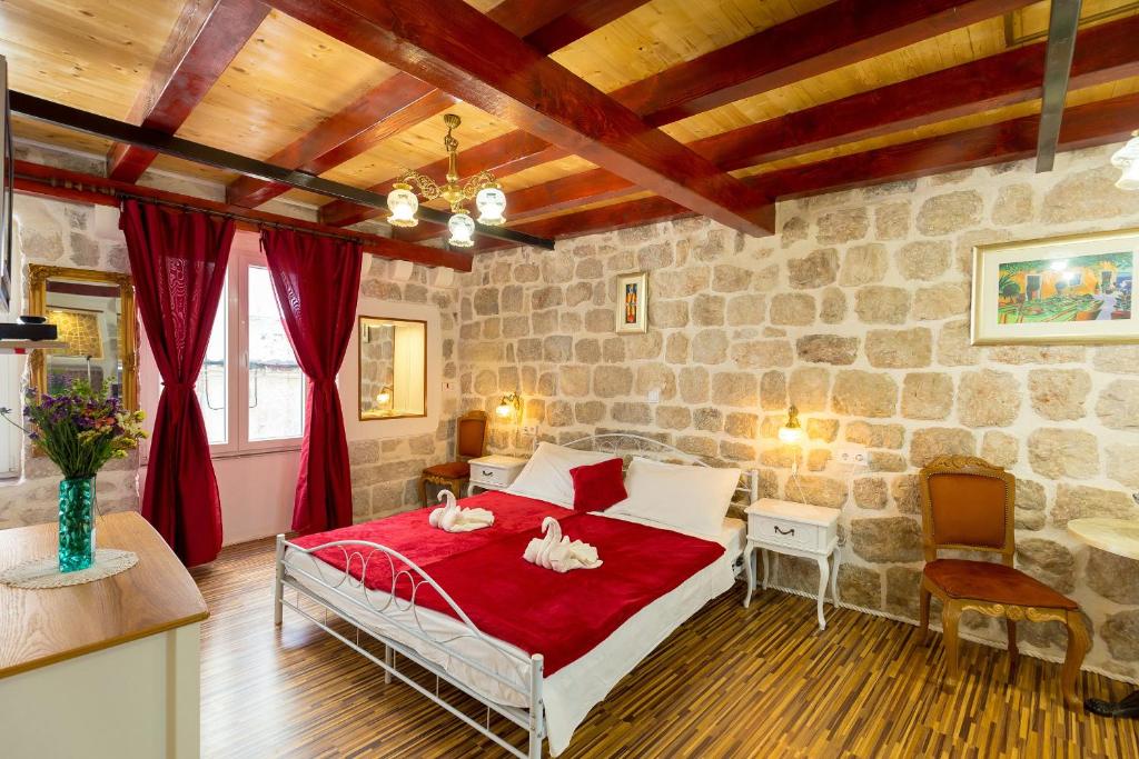 a bedroom with a bed and a stone wall at Juliette's Palace Studios in Dubrovnik