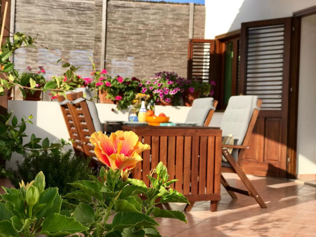 パンテレリアにあるLa Casa Grande di Pantelleria | PNL HHの花が咲くパティオ(テーブル、椅子付)