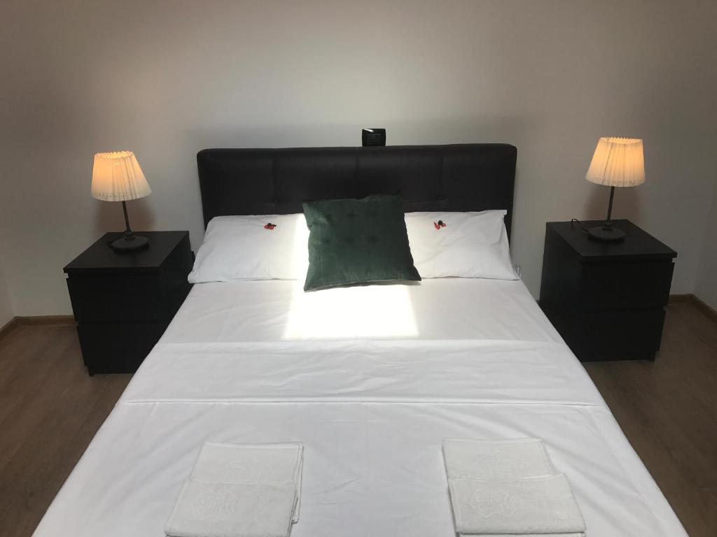 ブラショヴにあるOld City Houseのベッドルーム(白い大型ベッド、ランプ2つ付)