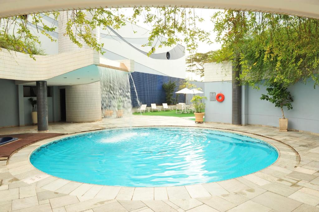 a swimming pool in a yard with a house at Quality Saint Paul Rio Preto in Sao Jose do Rio Preto