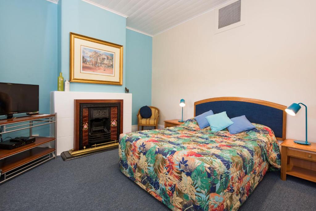 a hotel room with a bed and a fireplace at Ningana Heritage Houses in Mudgee