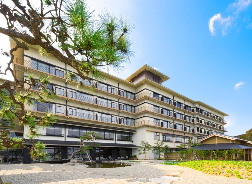 a large building with trees in front of it at Kagaya Bettei Matsunomidori in Nanao