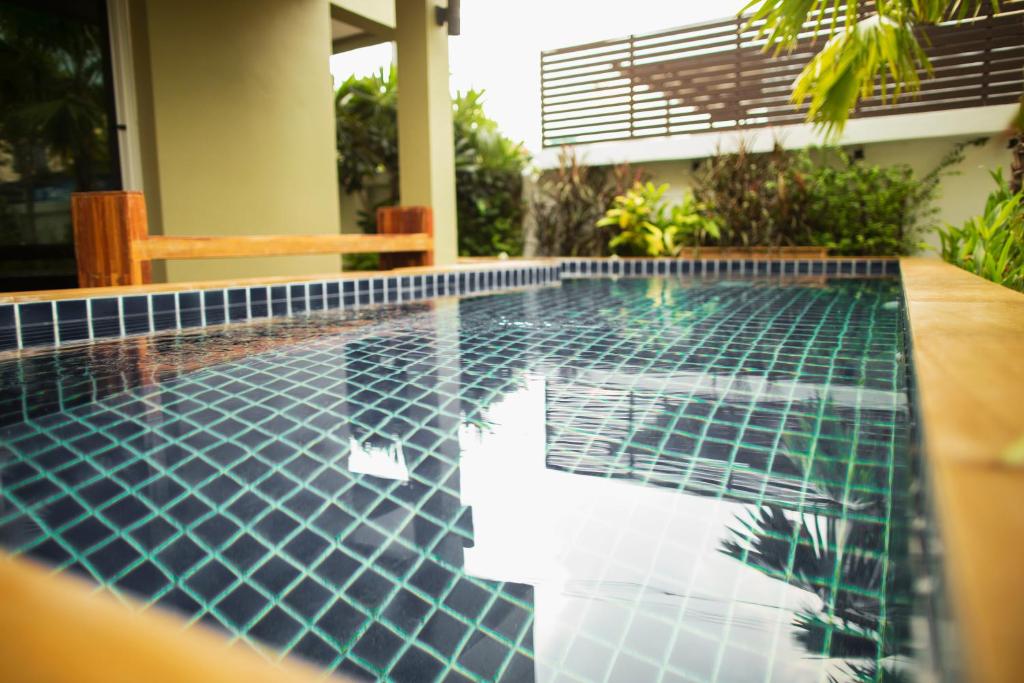 uma piscina no meio de uma casa em The Suvarnabhumi Apartment em Bang Kew Yai