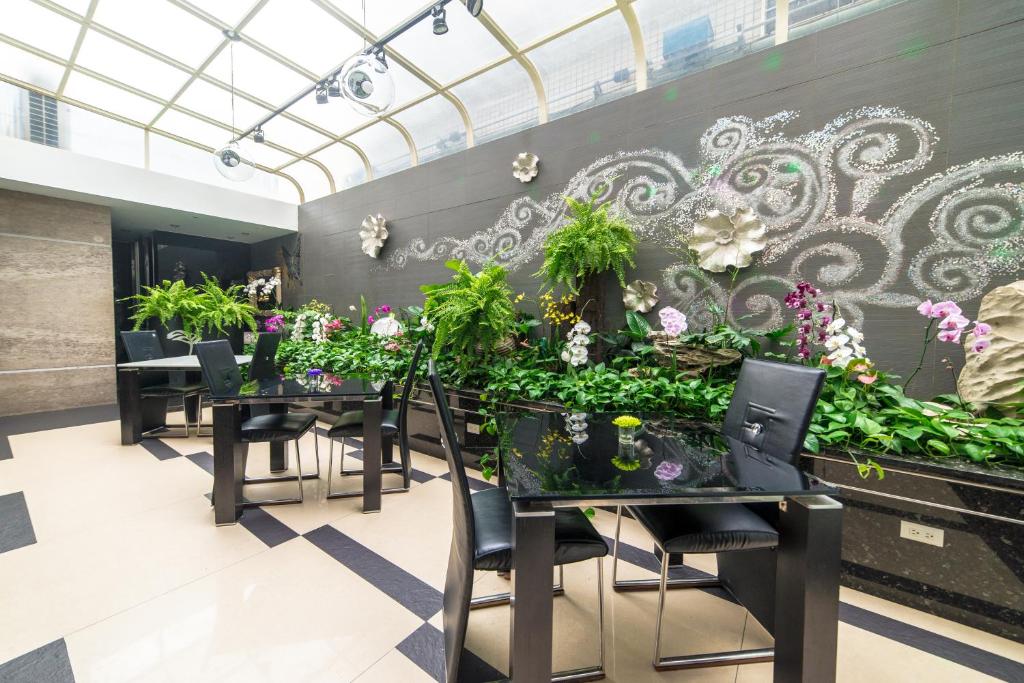 a dining room with tables and plants on the wall at Chiayi King Hotel in Chiayi City