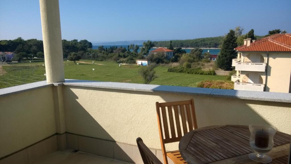 a table and chairs on a balcony with a view of a field at Apartment Vjera in Punat