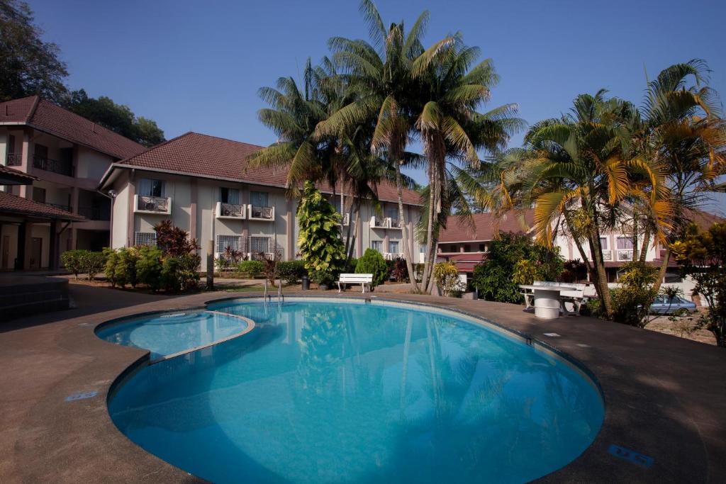 a large blue swimming pool in front of a building at Hotel Seri Malaysia Temerloh in Temerloh