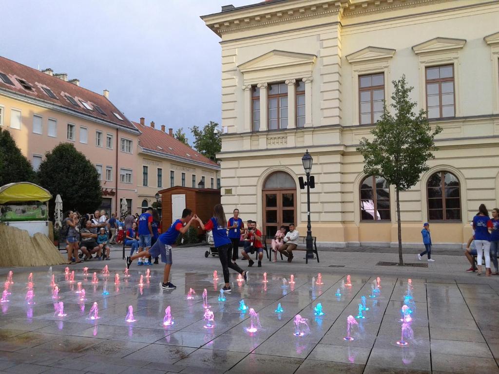 un gruppo di persone che giocano con le luci in una strada di Veronika Apartment a Székesfehérvár