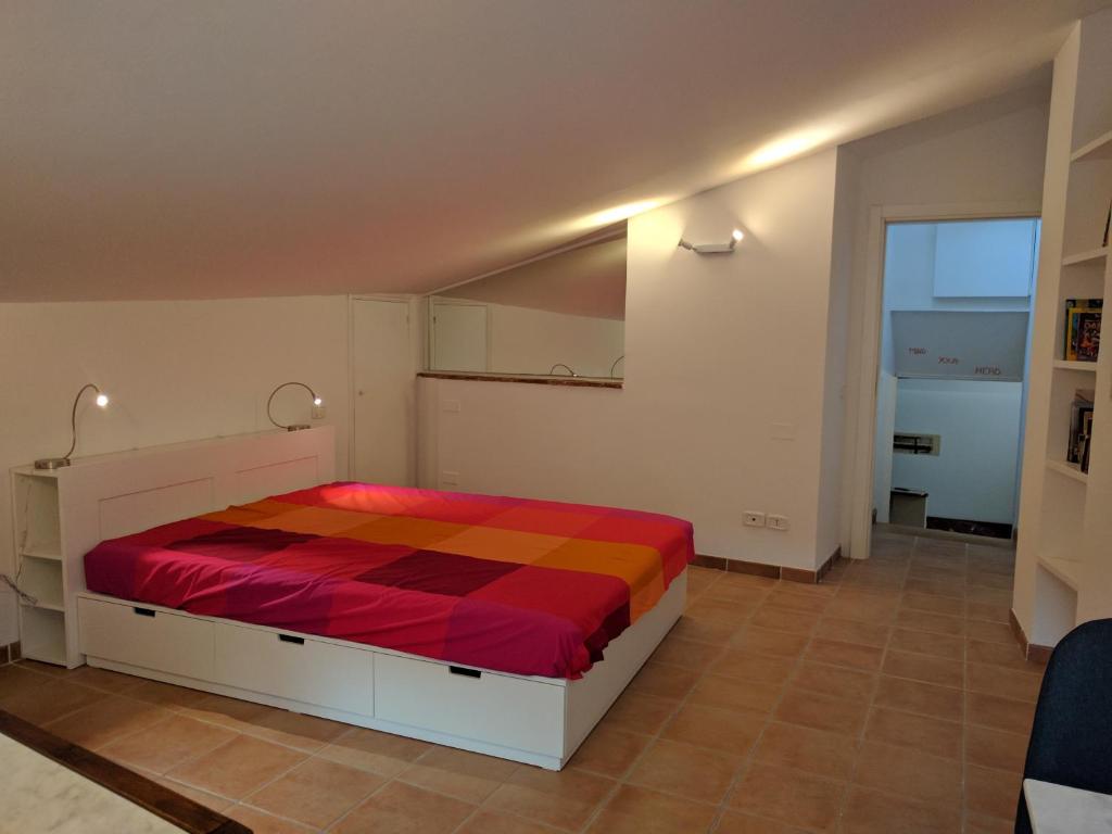 a bedroom with a bed with a red and orange blanket at La Casina di Perugia in Perugia
