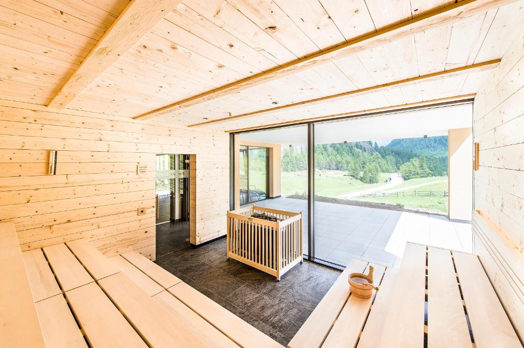 Casa de madera con una gran puerta de cristal en Hotel Gerstgras, en Maso Corto