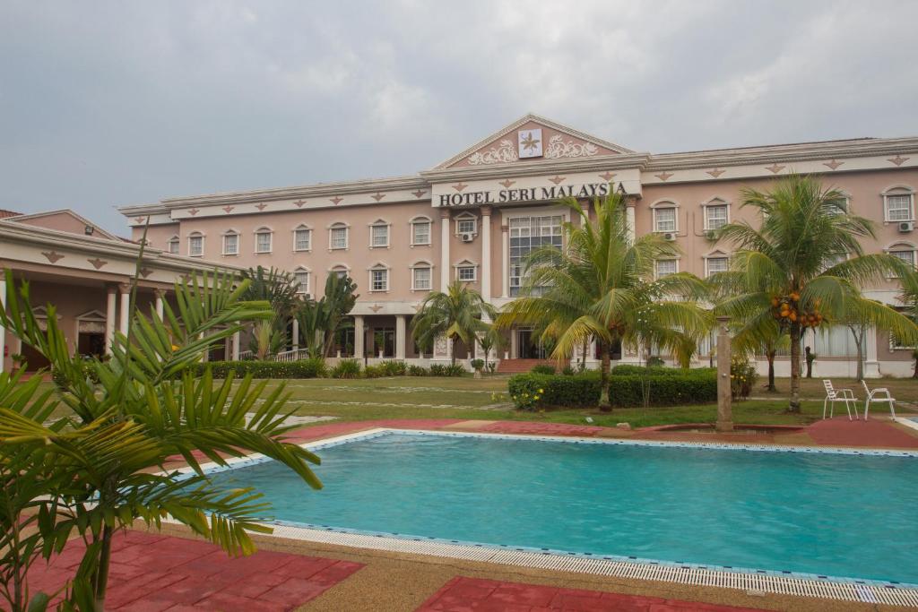 a hotel with a swimming pool in front of a building at Hotel Seri Malaysia Kulim in Kulim