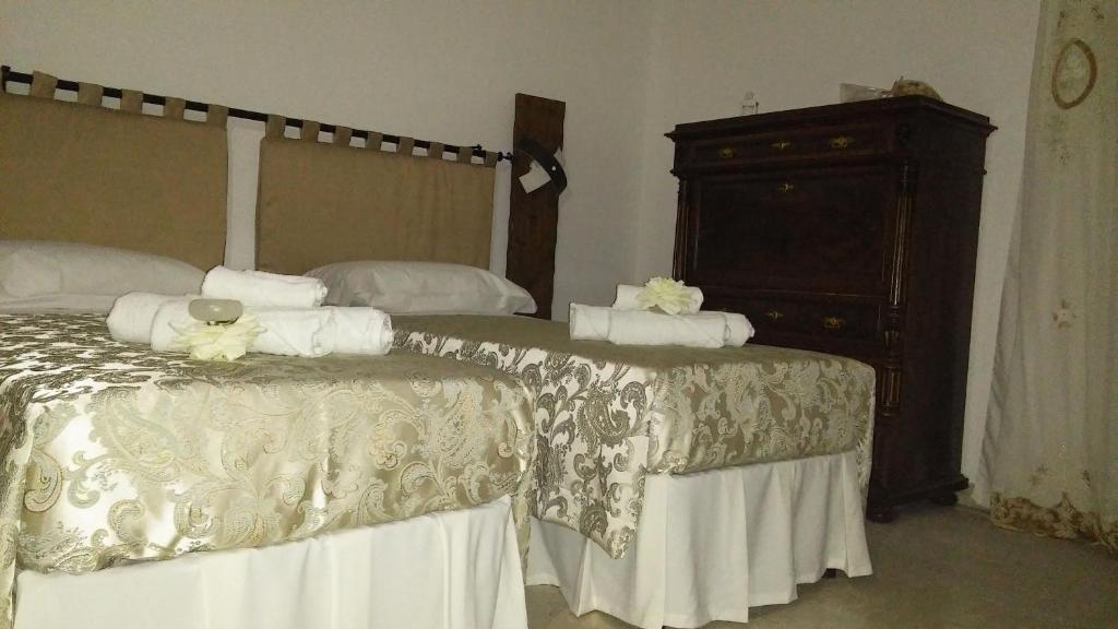 a bedroom with two beds and a dresser at Bed and Breakfast Elettra in Marconia