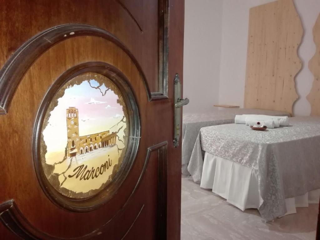 a room with a bed and a round mirror next to a table at Bed and Breakfast Elettra in Marconia