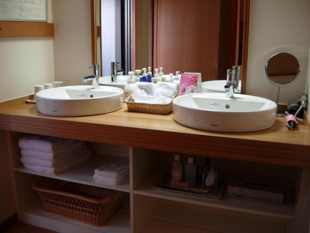 a bathroom counter with two sinks and a mirror at Yoshimatsu in Hakone
