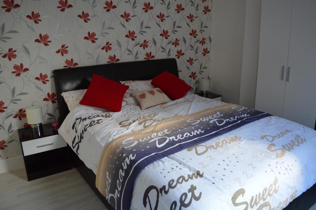 ein Schlafzimmer mit einem Bett mit roten Kissen darauf in der Unterkunft Victoria House in Poole