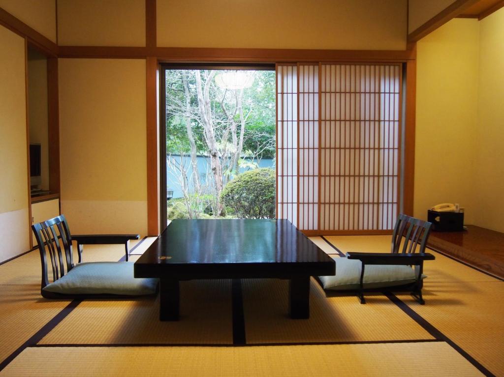 a dining room with a table and chairs and a window at Yoshimatsu in Hakone