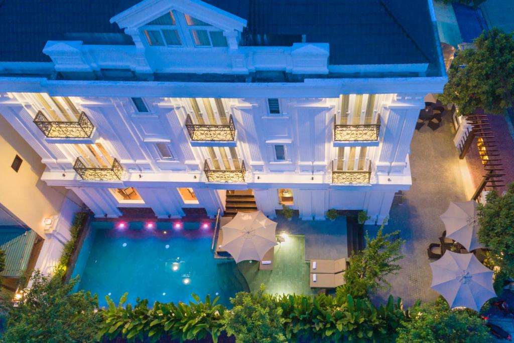 - une vue sur la piscine de l'hôtel et ses parasols dans l'établissement Hoi An Canal House, à Hội An